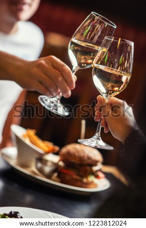 people eating and drinking in american restaurant, beer, hamburger, wine and other american specialites