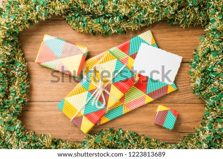 Christmas concept. Gifts on wooden boards with frame of garlands.