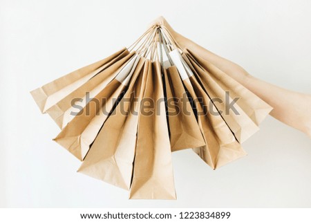 Black Friday sales discount concept. Craft paper bags in woman hand on white background.