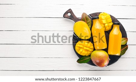 Mango and Mango fruit juice. On a white wooden background. Tropical Fruits. Top view. Free copy space.