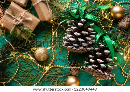 cones on a green background with Christmas decorations, sparkles and branches of spruce

