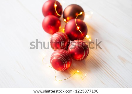 Christmas holiday background  with red Christmas balls and garland on white vintage wooden background. Close-up, selective focus.  Christmas and New Year concept