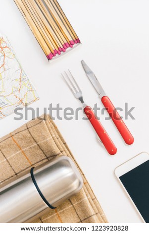 Creative Top view flat lay outdoors trip composition. Thermos map retro camera cutlery blanket white background copy space. Template weekend outing picnic nature tourism recreation