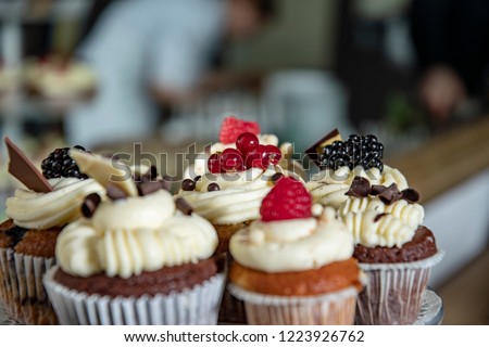 cupcakes with fruits and wedding cake and buffet in the background