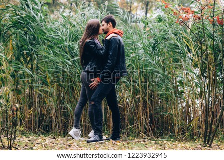 Romantic holidays guy and girls in autumn park.
Funny games of husband and wife in nature.