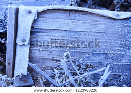 Wooden frosted board with snow on it iblue toned abstract texture.