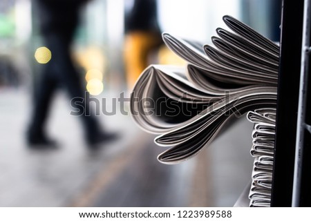 A heap of newspapers on a news stand on the background of a street Royalty-Free Stock Photo #1223989588