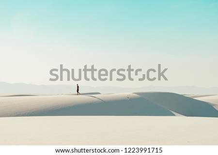 A man walking the sand dunes of White Sands National Monument in New Mexico, USA  Royalty-Free Stock Photo #1223991715