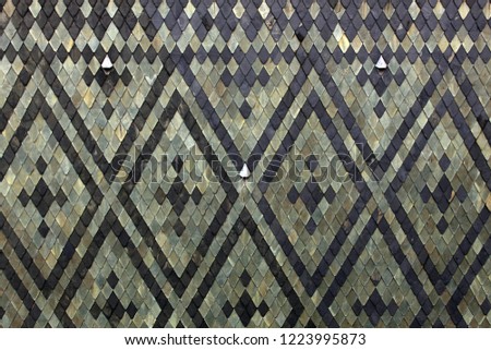 Tile roof of the cathedral. Green and black diamond shaped roof tiles. Geometric pattern background. Angular texture backdrop.