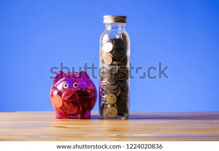 Saving concept with mason jar,coins and piggy bank on a blue background.