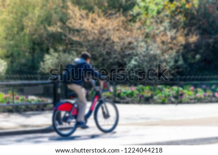 Blurred photo of unidentified young boy riding bike in a public park in beautiful green nature in summer time. doing exercise to be healthy and fit