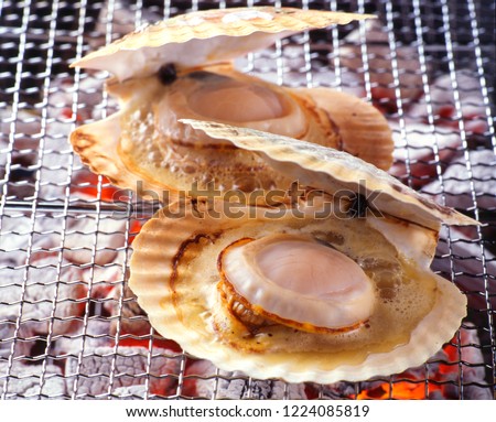 Fresh japanese scallop (Hotate) with shell on the grill with flames Royalty-Free Stock Photo #1224085819