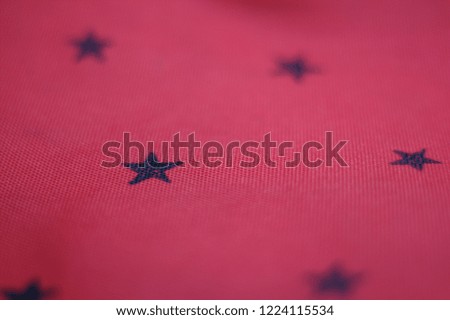 Red striped background with many black stars.