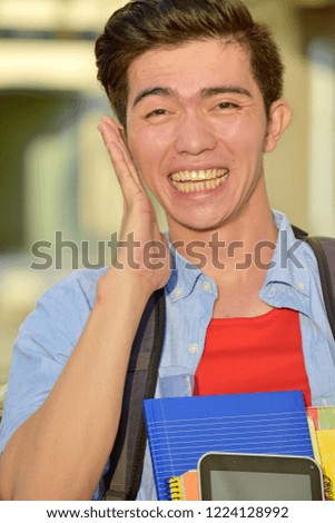 Minority Male Student Smiling With Notebooks