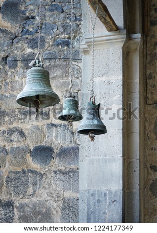 three church bells of small, medium and large size hanging in chains, Vardzia, Georgia