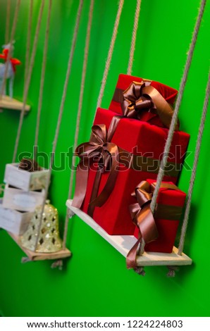 Christmas red gift boxes on shelf of green wall