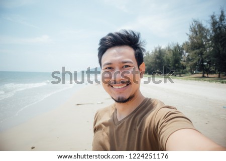 Cheerful and happy face of asian man selfie himself on the beach.
