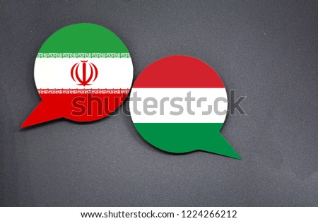 Iran and Hungary flags with two speech bubbles on dark gray background