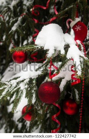 Red Christmas balls on a tree in a snow outdoors