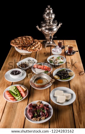 Samovar and traditional Turkish breakfast table with bacon, cheese, egg, honey