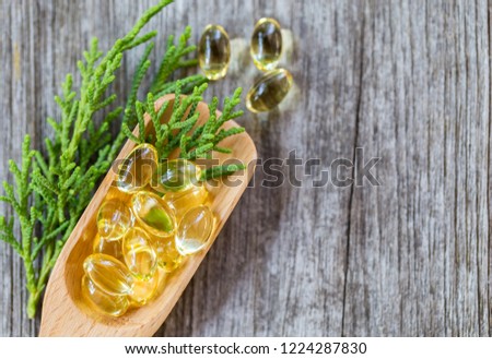 Healthy Vitamins on a Wooden Spoon,Healthy Vitamins on a Wooden Spoon,Fish oil capsules on wooden ,vitamin D supplement,vegetables and vitamins,Fish oil capsules with omega 3.