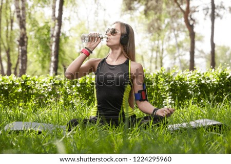 young blonde girl in the Park drinking water during her training
