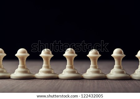 white chess pawns on wooden table
