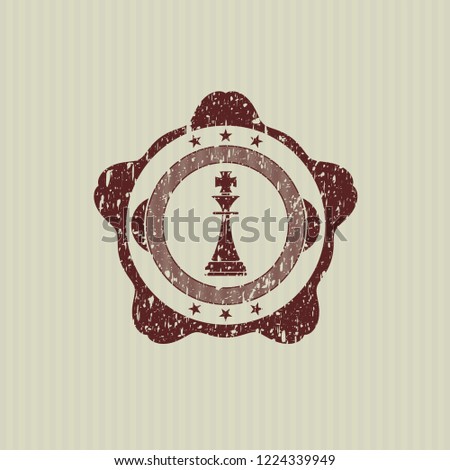 Red chess king icon inside distressed rubber grunge texture seal