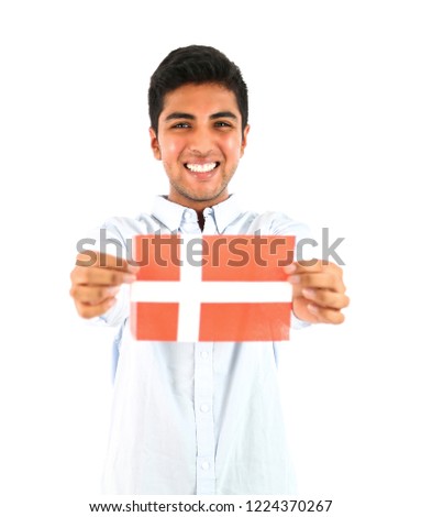 Happy young man holding the flag of Denmark against a white background