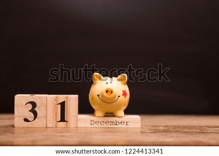 Calendar date for End of Financial Year, 31 december with piggy bank on dark background, with copy space.
