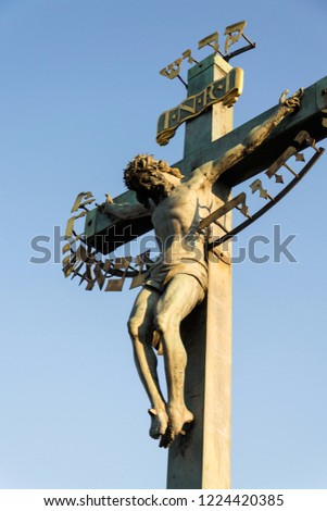 Beautiful Jesus Christ crucifixion bronze statue during sunrise, Statuary of the St. Cross with Calvary, Charles Bridge, Prague, Czech Republic, sunny day, clear sky