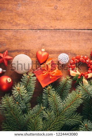 Christmas background. A lot of red vintage baubles, gift box and fir tree over dark wooden board. Christmas concept