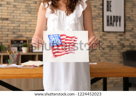 Woman holding watercolor painting of American national flag