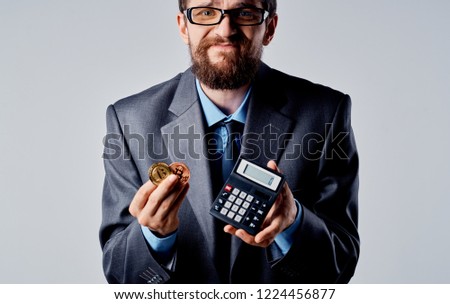 man in a suit with a bitcoin cryptocurrency calculator                 