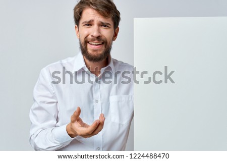 a man in a white shirt stands in front of a white drawing paper                          
