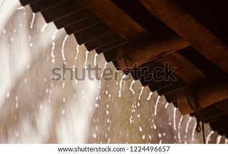 Falling rain waters from a rooftop isolated unique blurry photo