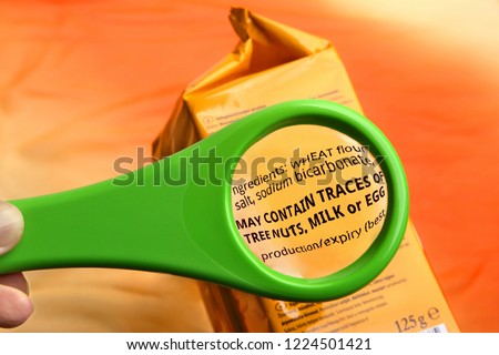 Magnifying glass on food ingredients and additives label.  Reading ingredients list on food package with magnifying glass.
 Royalty-Free Stock Photo #1224501421