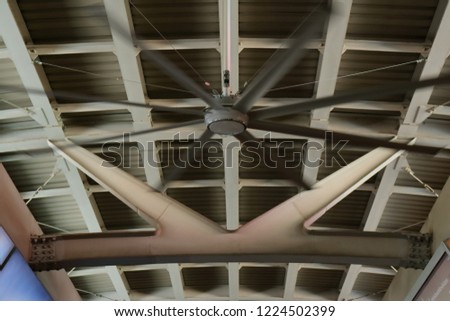 closeup picture of big fan fixed to the ceiling of sky train station 