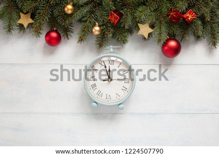 Christmas holiday background with vintage alarm-clock, balls, stars and garland on light blue wooden background. Close-up, top view.  Christmas and New Year concept