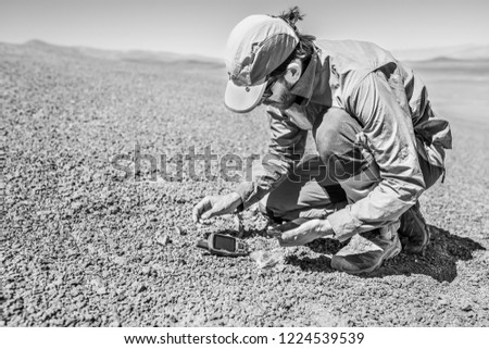 Atacama desert, the driest desert in the world. Its old sand slopes keep lands from millions of years ago what makes easier to find meteorites on the ground. A meteorite hunter man doing his work