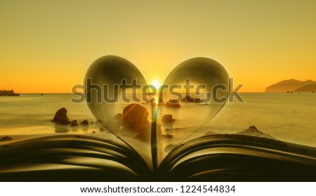 Book with heart-shaped leaves with the sea at sunrise in the background, Spain