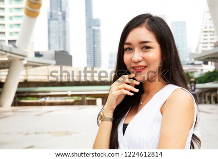 Beautiful Asia girl smile portrait on walking street and building background.	