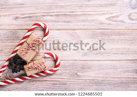 candy canes and christmas gift on brown wooden rustic vintage background.