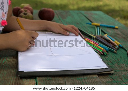 the child draw picture with colorful pens on the wooden green table in the nursery or school for activity concept. creative ideas for child development.back to school.