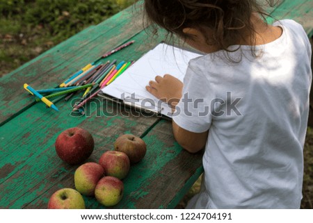 the child draw picture with colorful pens on the wooden green table in the nursery or school for activity concept. creative ideas for child development.back to school.