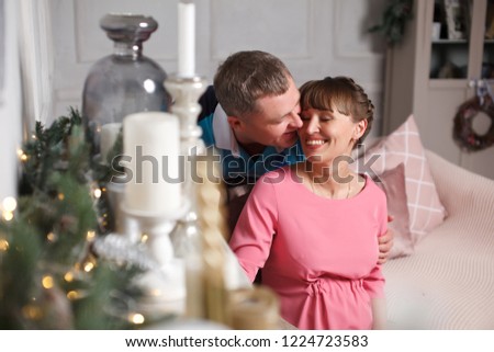 Married couple in Christmas interior studio.