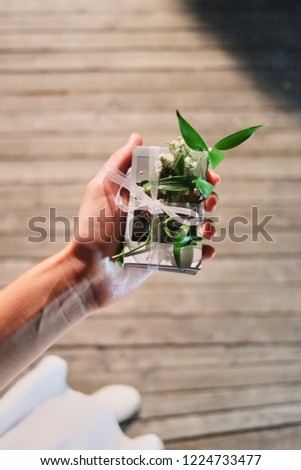 Female hands hold gift pack of photos. View from above. Wrapping festive background.