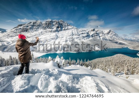 Beautiful girl with red hat taking picture with smartphone near Peyto Lake, Banff, Canada. Royalty-Free Stock Photo #1224764695