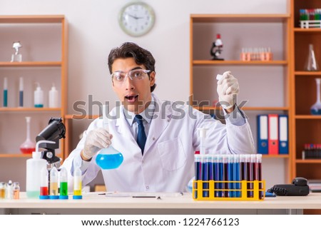 Young handsome biochemist working in the lab 