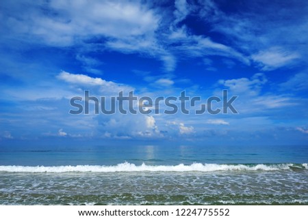 Beautiful romantic navy blue sky with amazing white clouds, sand beach of the blue sea. Beautiful summer sky and blue sea with white waves